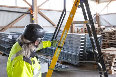 Worker checking stacked galvanized steel trays in the hall