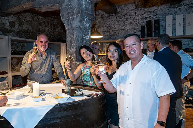 Guests raise a toast at the apéro in the vaulted castle cellar.