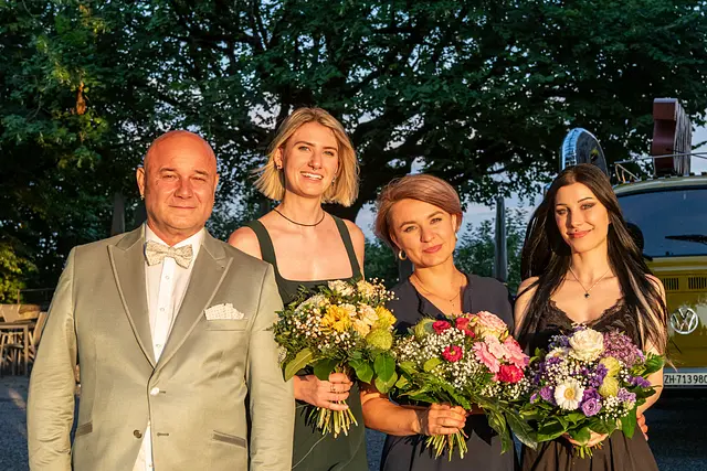 Cosimo Russo hands bouquets to the three new partners, all in evening dress.